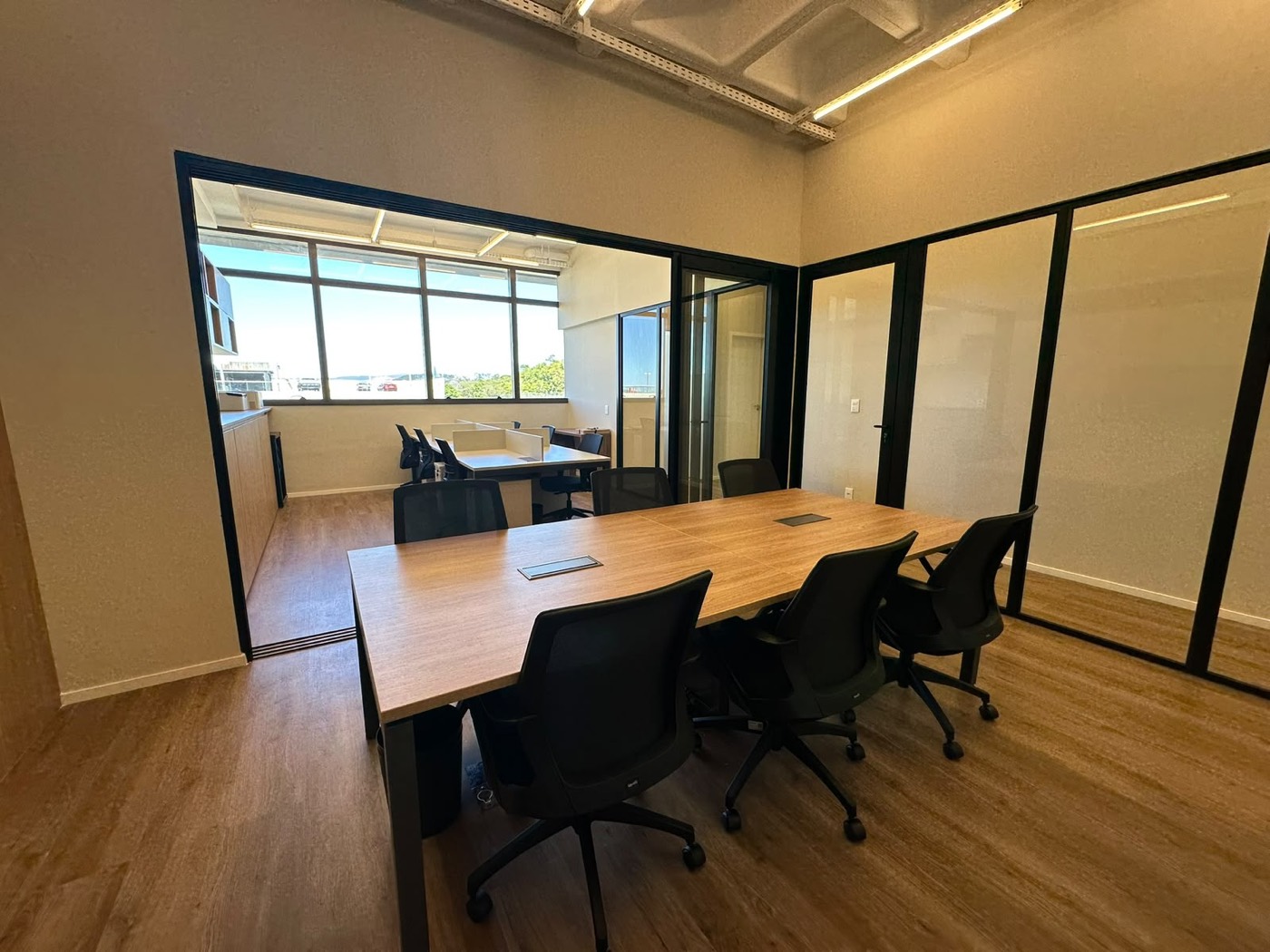 Sala de reuniões com divisórias de vidro em obra comercial